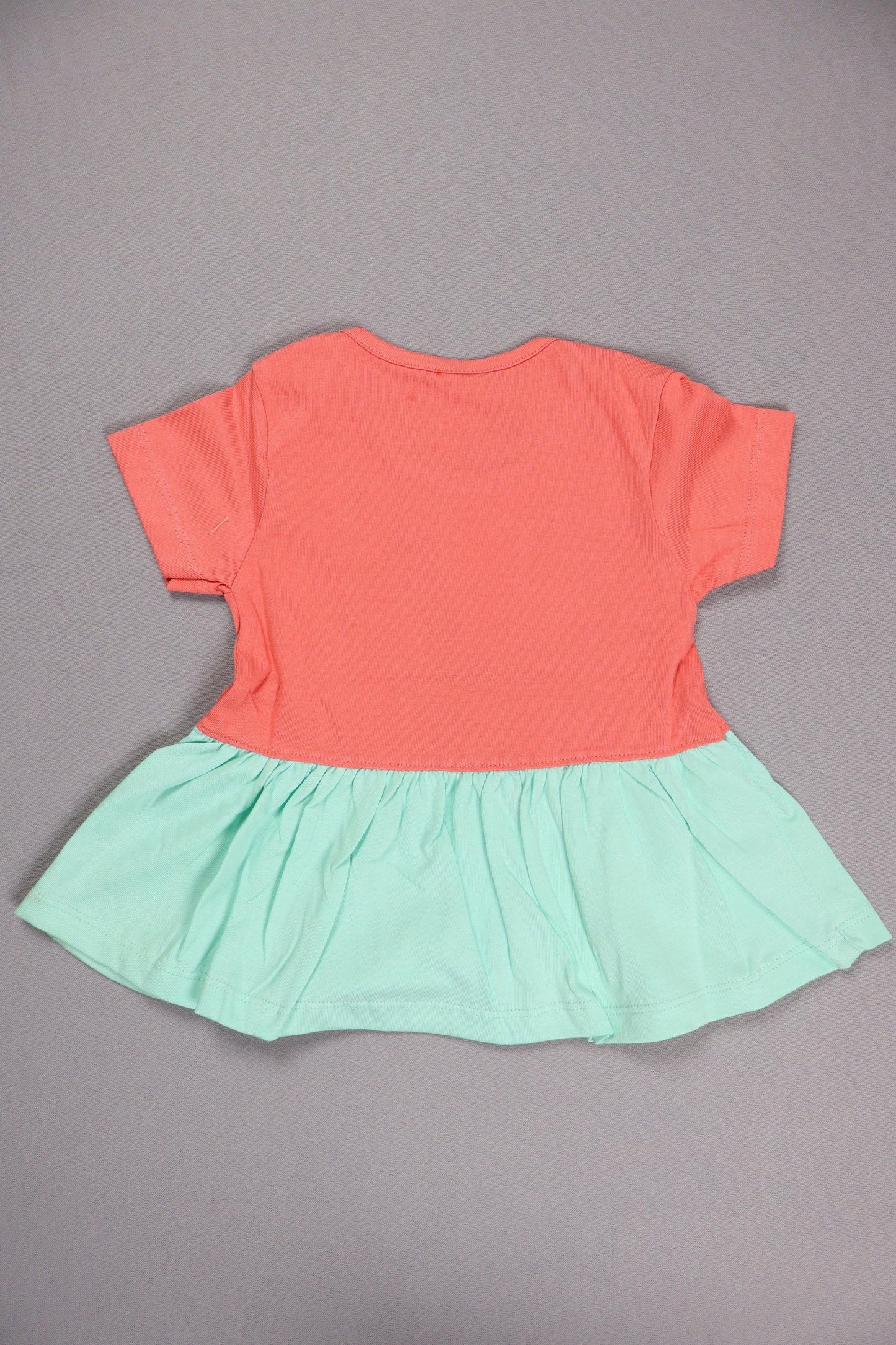 Back view of a short sleeve cotton kids dress with coral top and mint green skirt