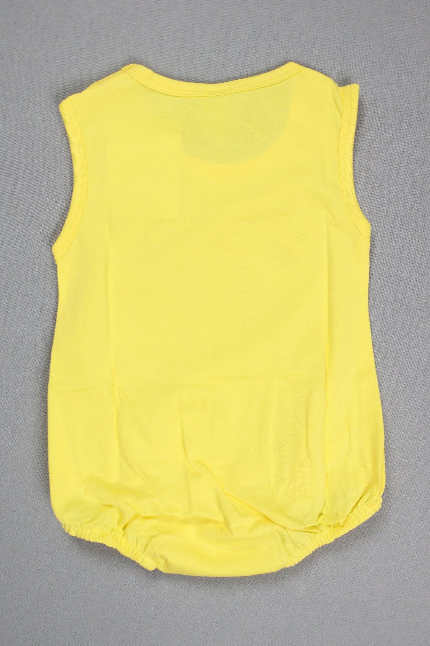Yellow sleeveless top on a gray background
