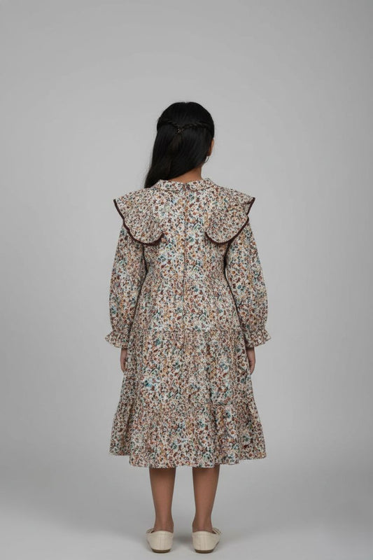 Woman wearing a floral dress with ruffled collar on a gray background