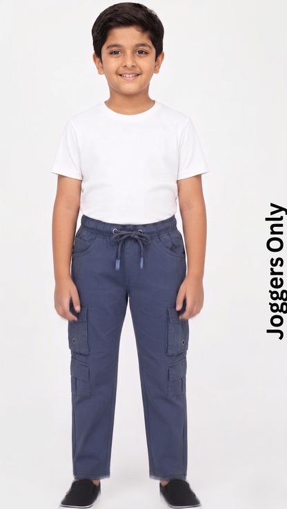 A kid wearing FYST brand lightweight navy blue cargo joggers featuring an elastic drawstring waistband and multiple functional side flap pockets on each leg for a sporty utility look.