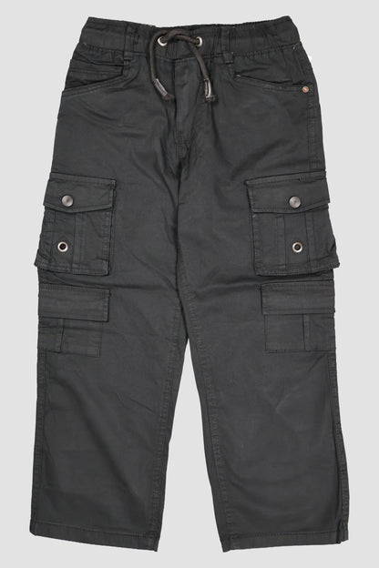 A pair of children's utility cargo pants in a deep Black. The pants feature a comfortable elastic waistband with a matching drawstring, two standard side pockets, and two large multi-compartment cargo pockets on the legs with secure button closures. They are shown as a flat lay against a neutral grey background.