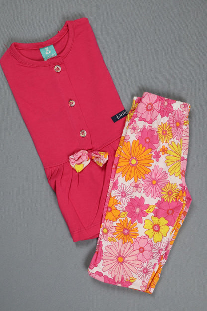 Pink baby outfit with floral pants on a gray background
