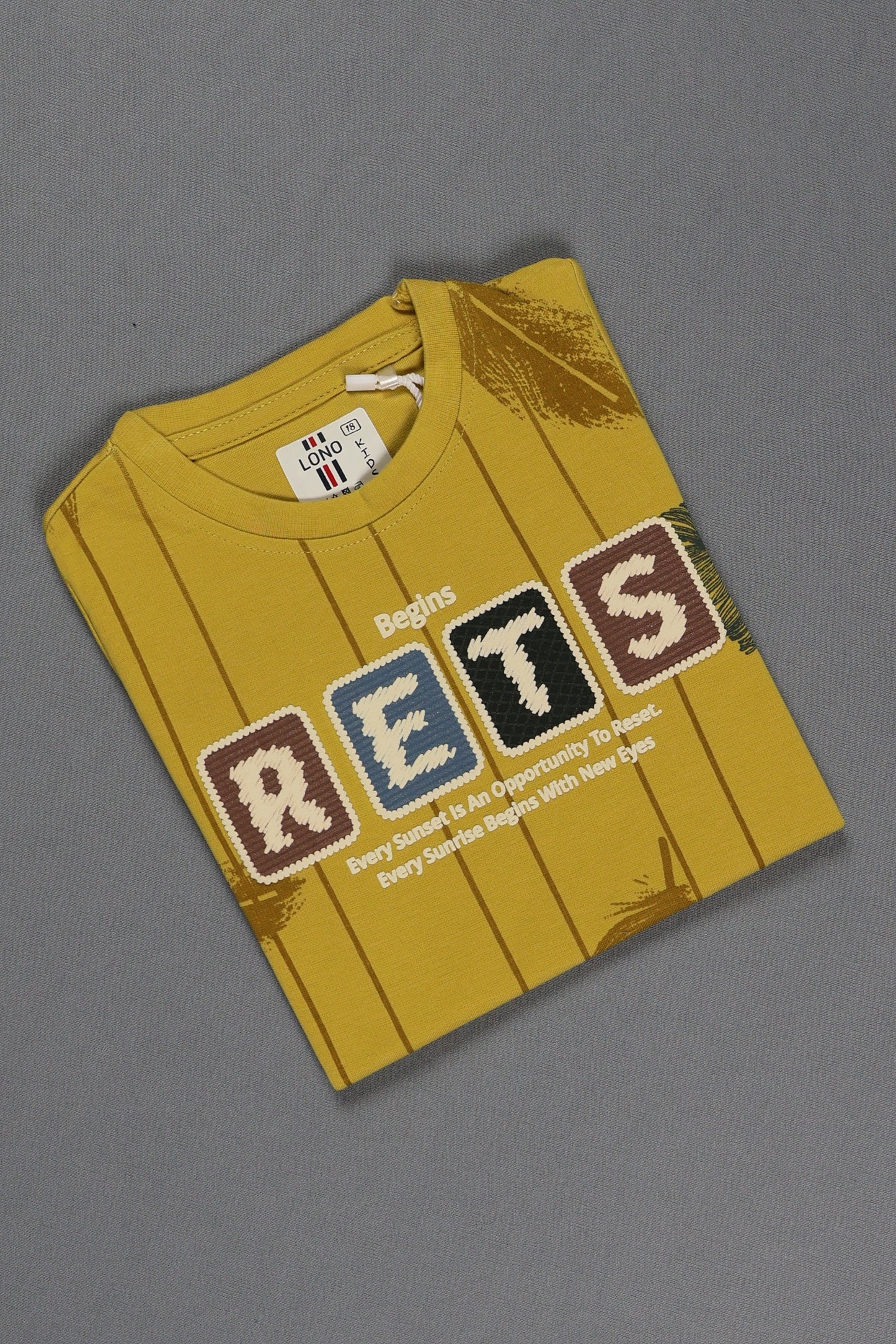 Yellow t-shirt with colorful text on a gray background