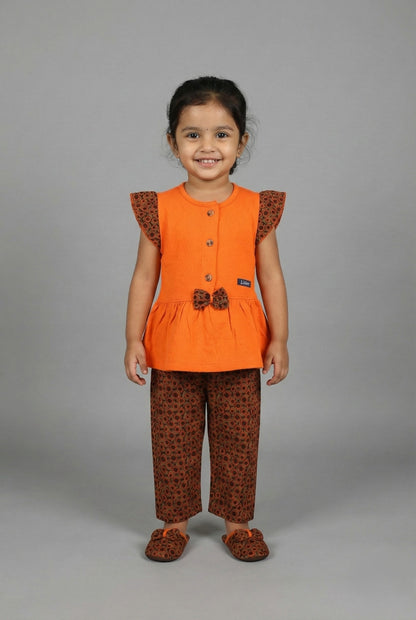 Flat lay of a two-piece girls' outfit featuring a folded orange button-down top and matching brown capri pants with an orange circular print.