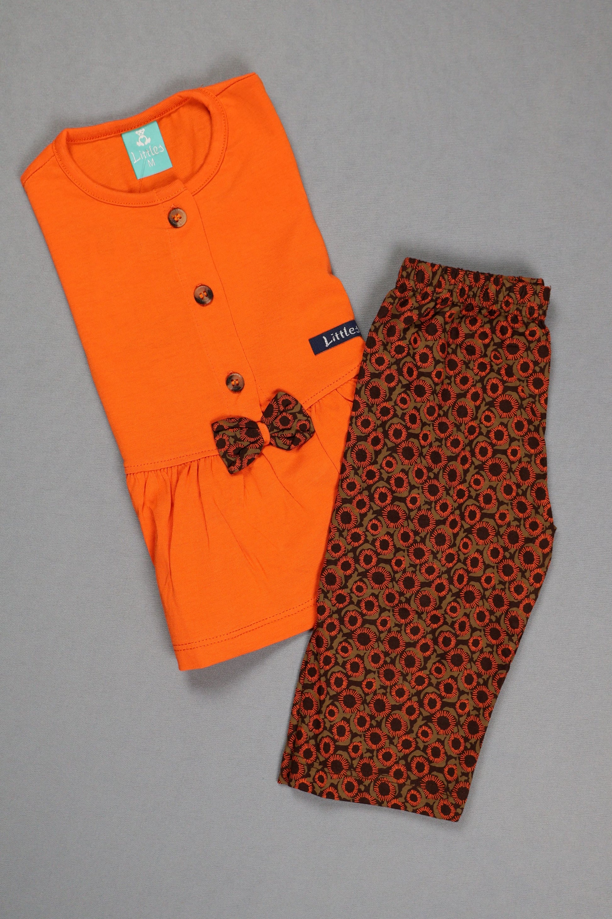 Orange t-shirt with a patterned design on a gray background