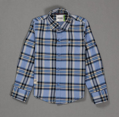 Blue and black plaid cotton kids shirt with long sleeves and front pocket on grey background