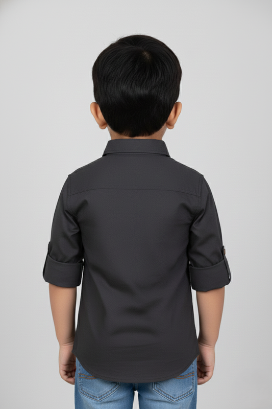 Child wearing a dark gray shirt on a light gray background