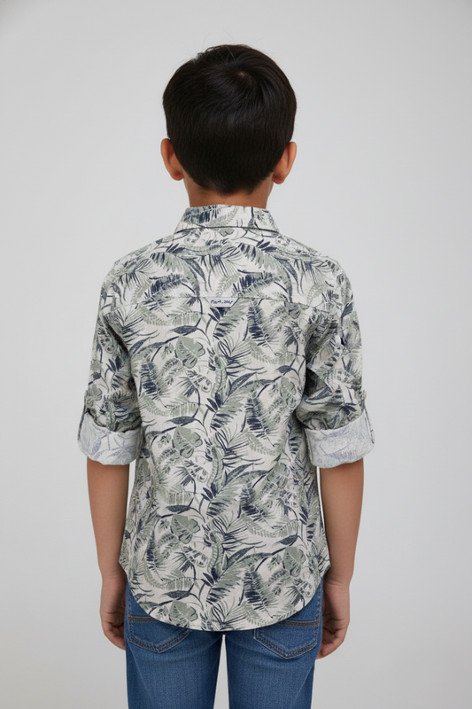 Person wearing a patterned shirt with rolled-up sleeves on a plain background