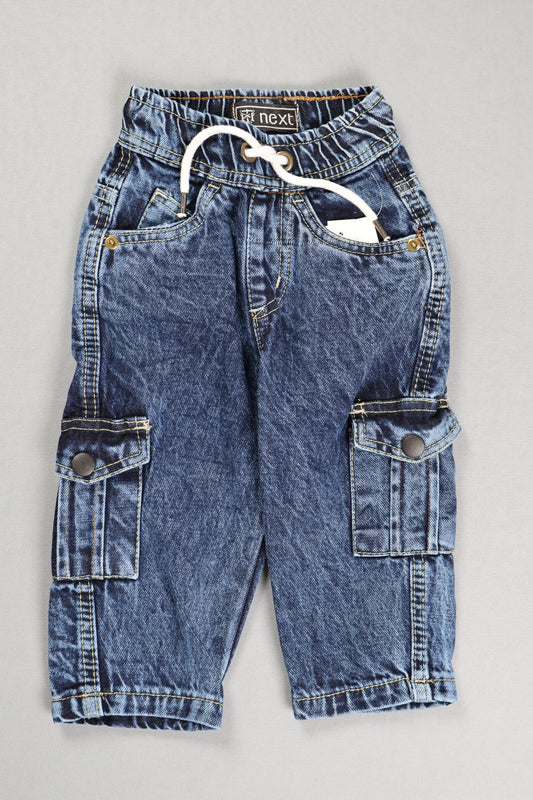 Folded blue jeans on a gray surface