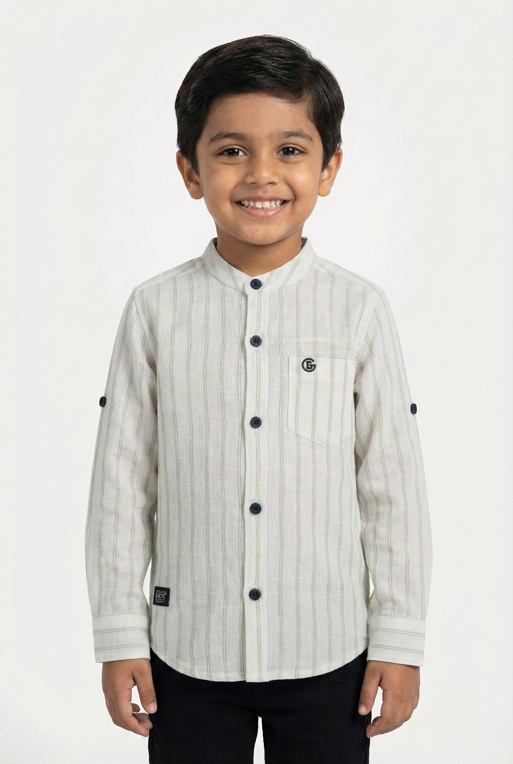 A young boy wearing a light grey and white vertical striped full-sleeve shirt from Fyst Fashion. The shirt features a modern mandarin collar, a single chest pocket, and dark buttons. The sleeves are rolled up to the elbow and secured with button tabs. The child is smiling and standing against a plain white background.