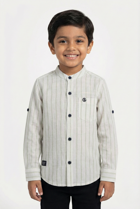 A young boy wearing a light grey and white vertical striped full-sleeve shirt from Fyst Fashion. The shirt features a modern mandarin collar, a single chest pocket, and dark buttons. The sleeves are rolled up to the elbow and secured with button tabs. The child is smiling and standing against a plain white background.