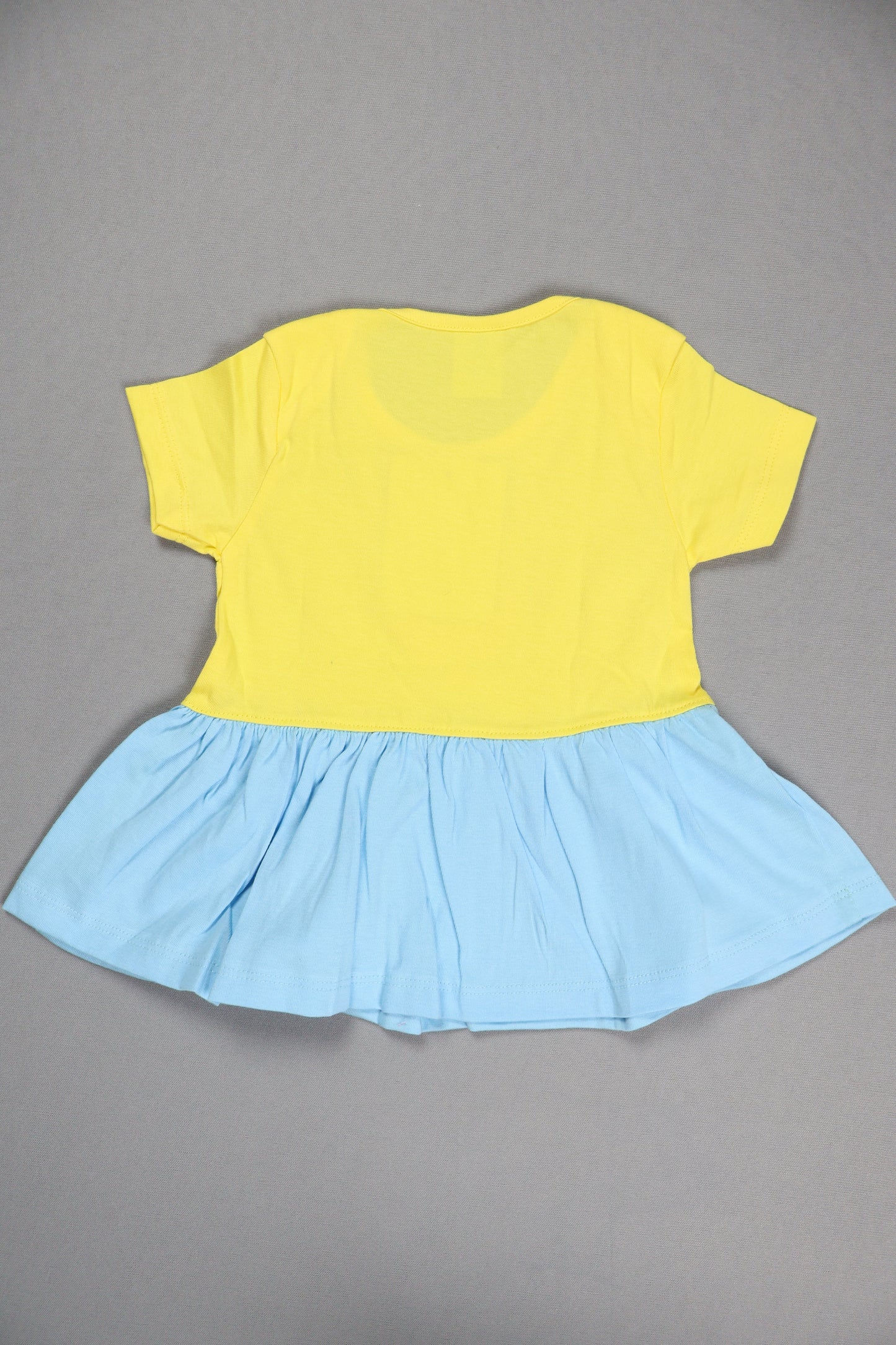 Yellow top and blue skirt on a gray background