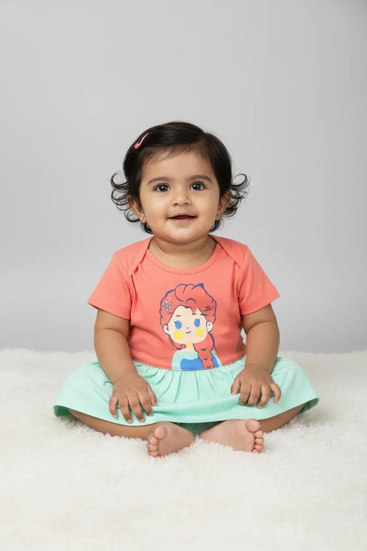 Infant wearing peach and green cotton color-block princess frock, sitting on white fur