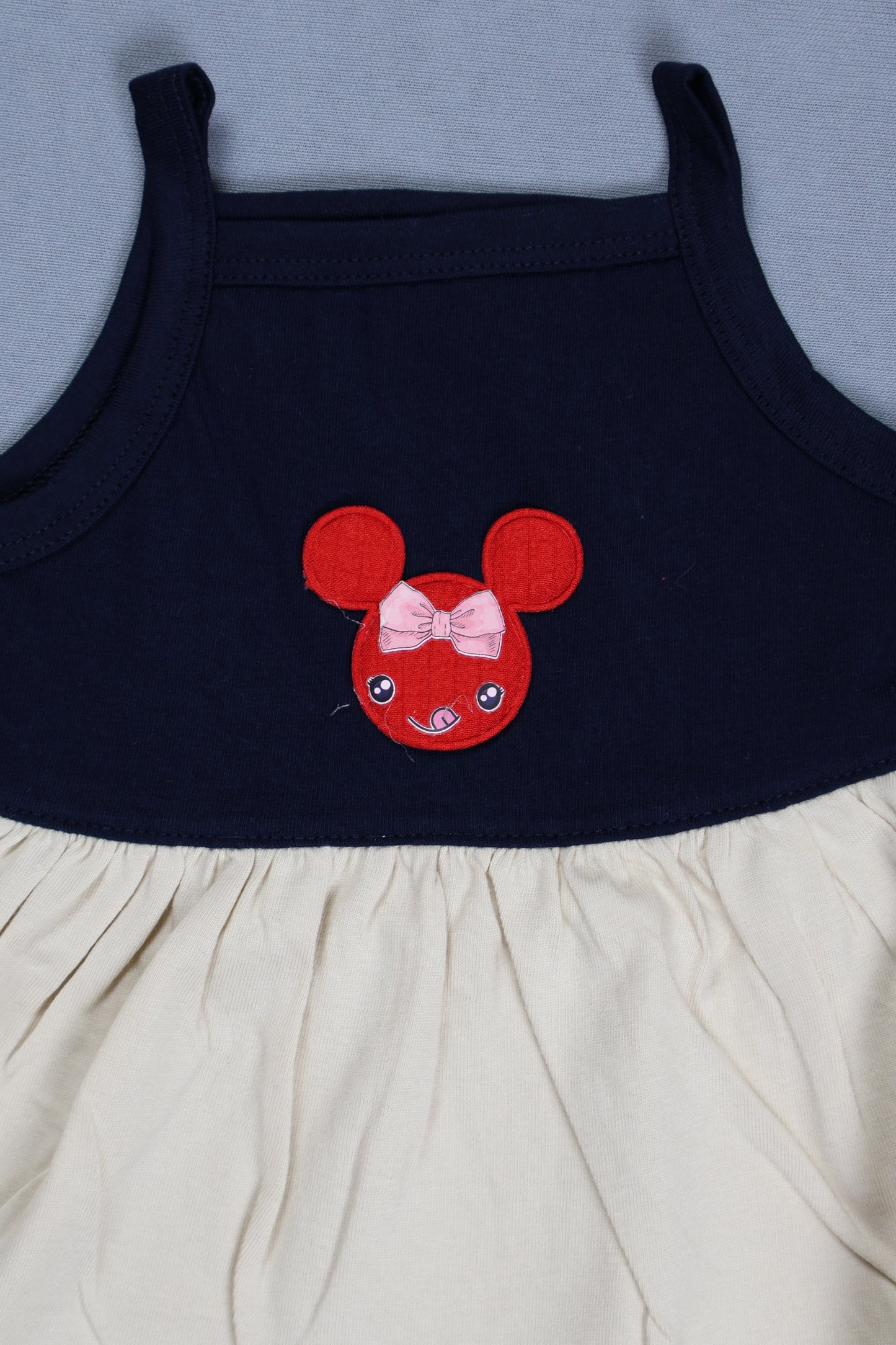 Navy blue dress with a red mouse head design on a light gray background