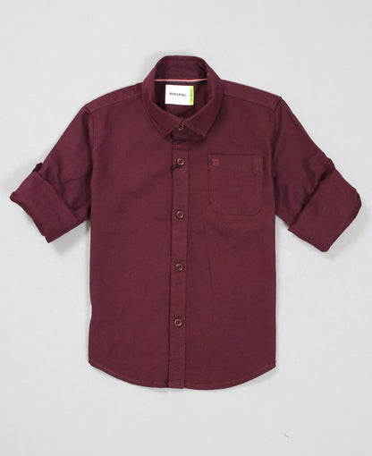 Maroon shirt with rolled-up sleeves on a light gray background