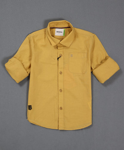 Yellow shirt with rolled-up sleeves on a gray background