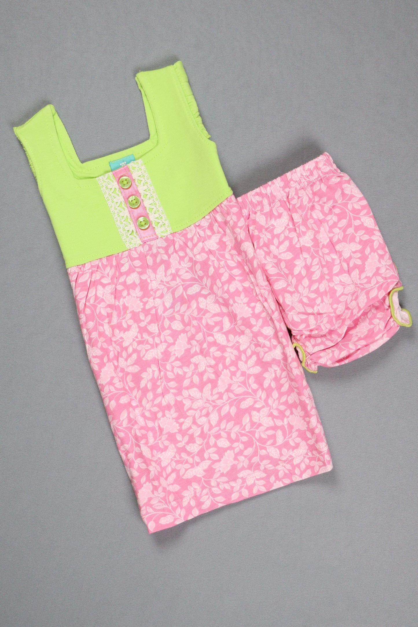 Pink floral fabric with a green patch on a gray background