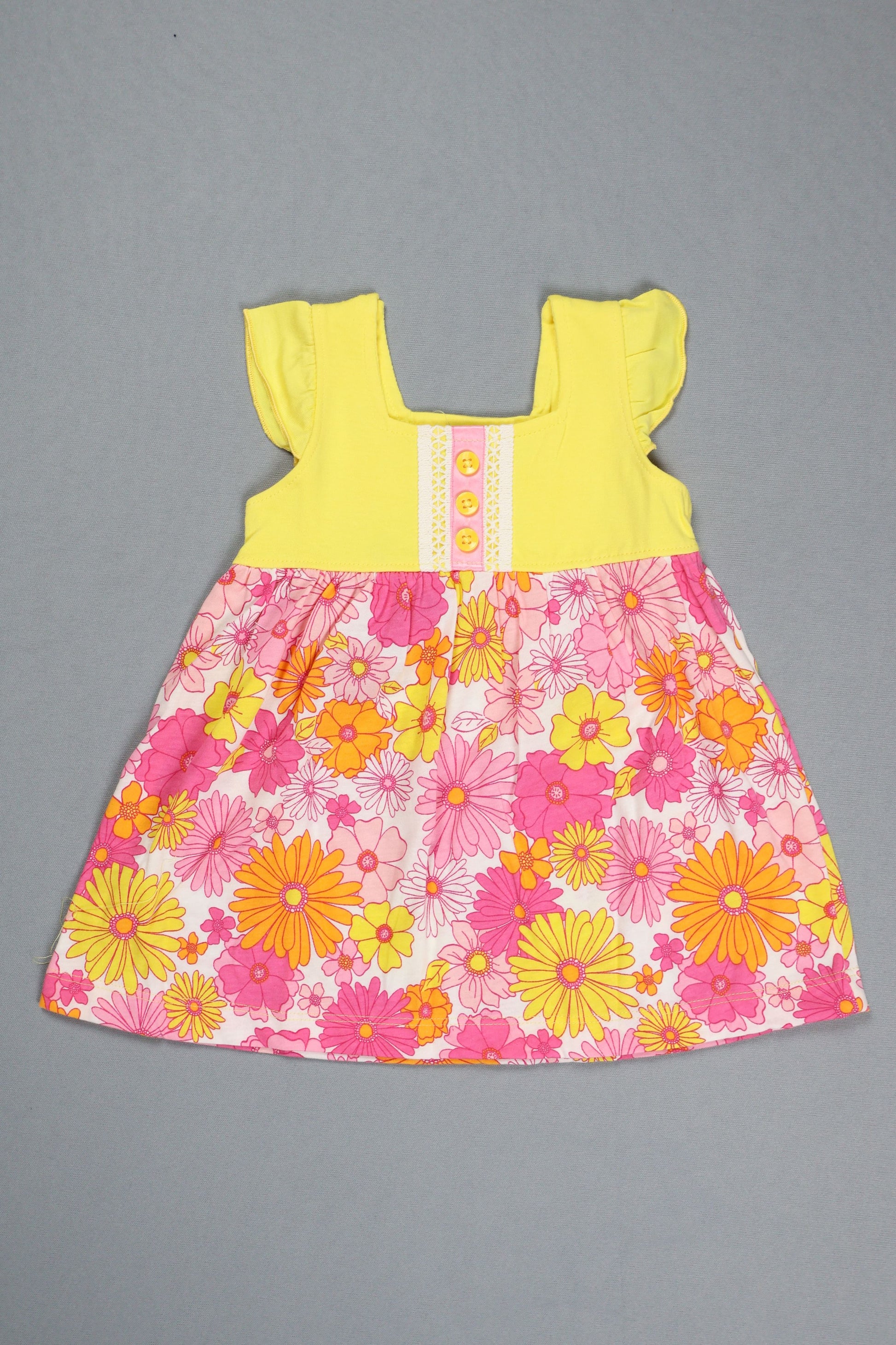 Floral dress with pink and yellow flowers on a gray background