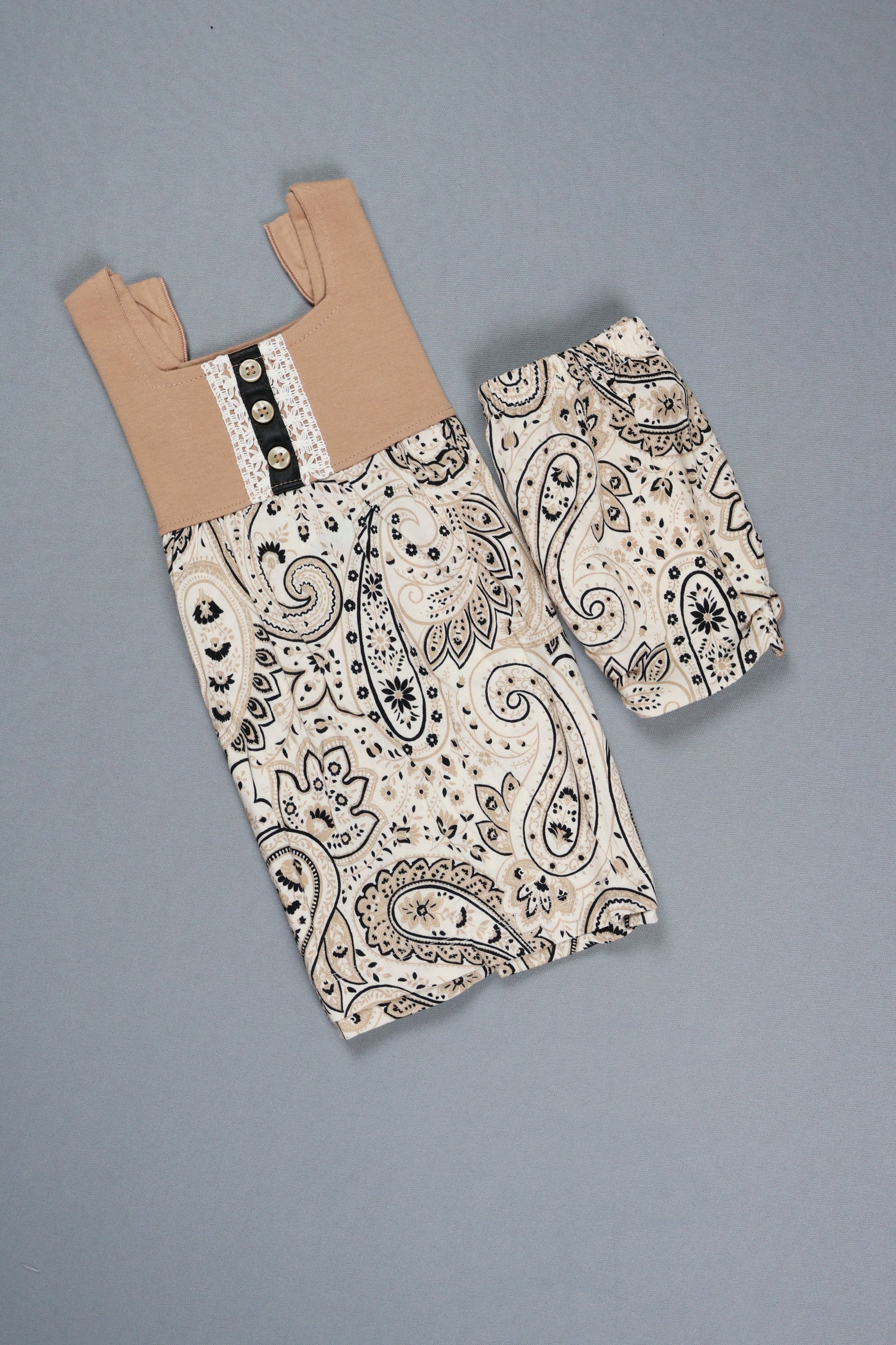 Paisley-patterned fabric with cardboard on a gray background