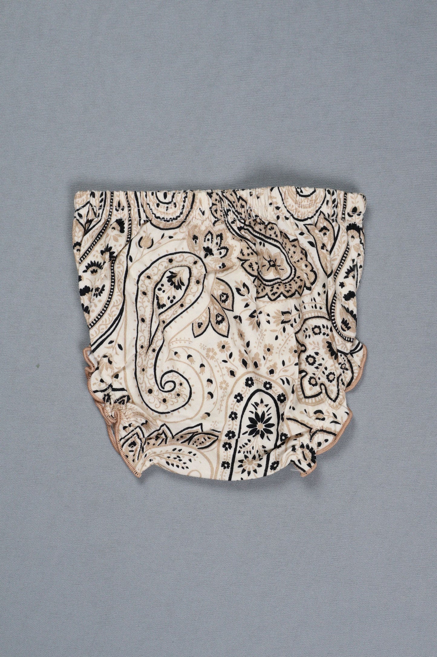 Decorative ceramic shard with black patterns on a gray background