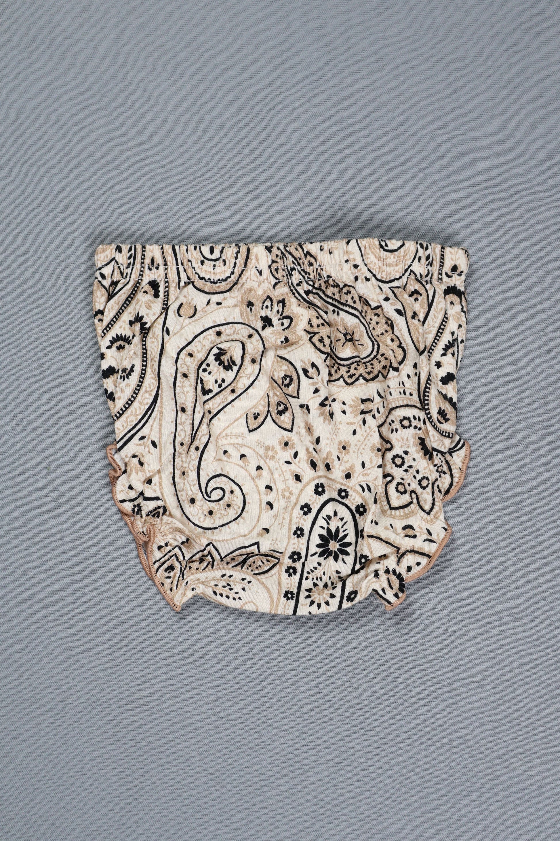 Decorative ceramic shard with black patterns on a gray background